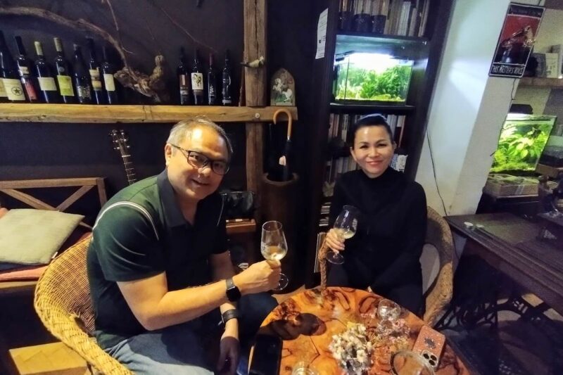 Two people enjoying a wine tasting session in a cozy indoor setting during the Private Small Carpathian Wine Discovery tour, surrounded by wine bottles and rustic decor.
