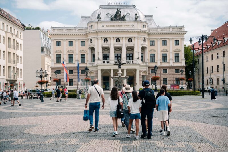 Clients strolling in Bratislava in front of Old Bratislava Theatre Building during Transfer from Budapest to Vienna with Bratislava City Tour