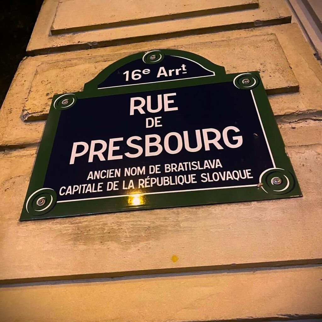 Bratislava and Paris, A street sign in the 16th arrondissement of Paris labeled "Rue de Presbourg," noting that Presbourg was the former name of Bratislava, the capital of the Slovak Republic. The sign has a traditional French street design, mounted on a beige stone wall.