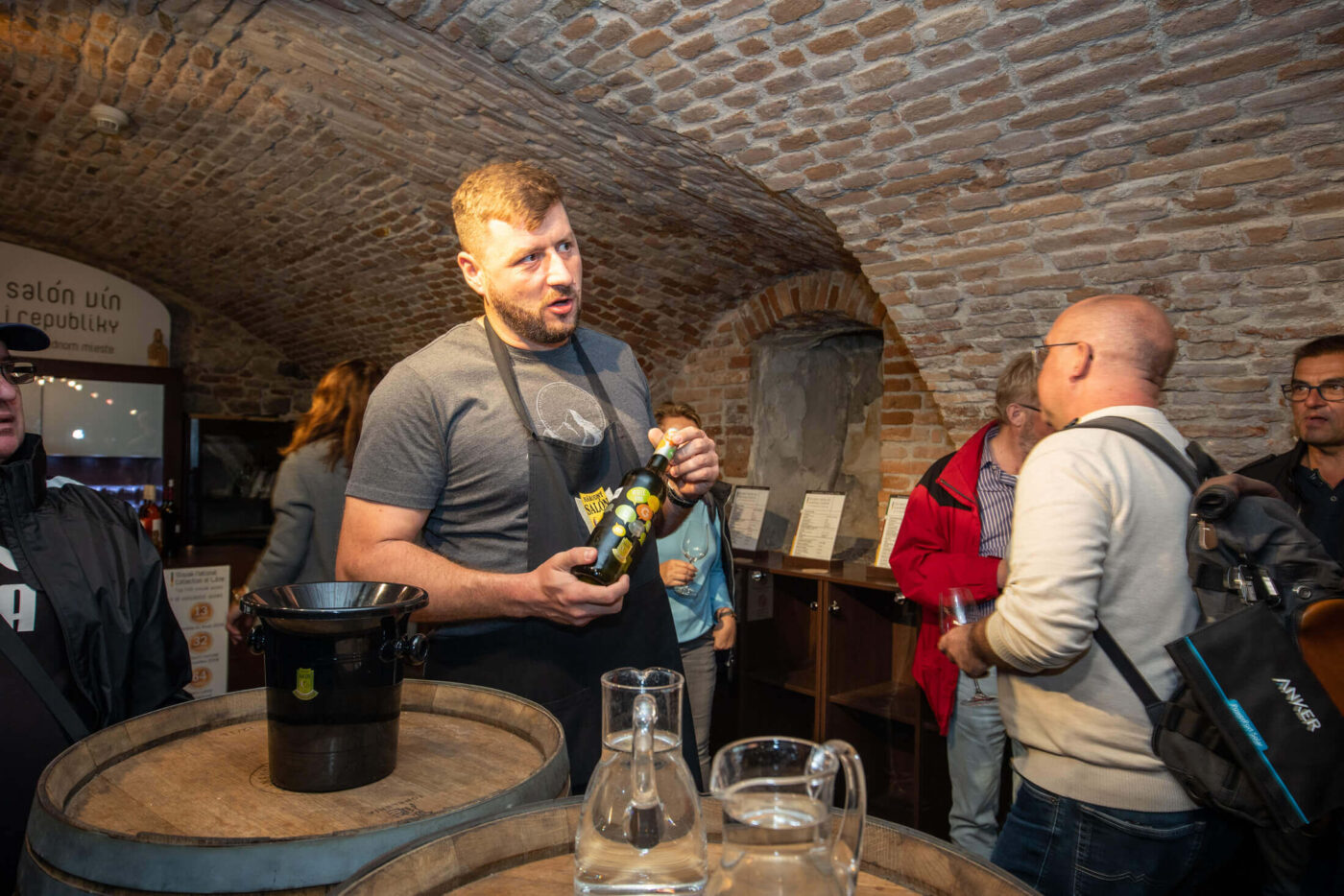 Sommelier holding a bottle of Dunaj wine at the Národný salón vín Slovenskej republiky — the Slovak National Wine Salon in Bratislava's Appony Palace