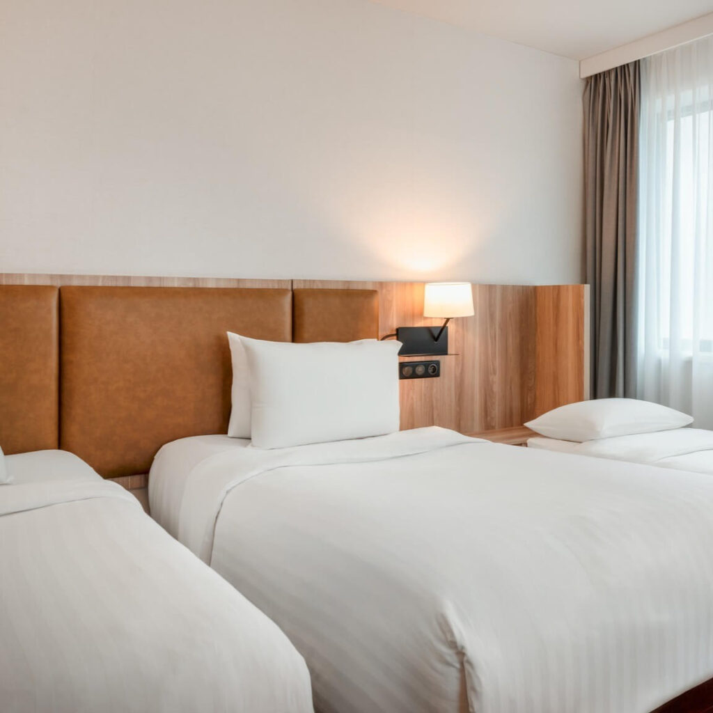 Modern twin room at AC Hotel by Marriott Bratislava Old Town with leather headboard and warm lighting
