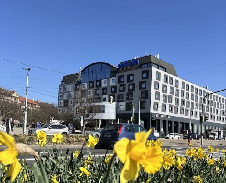 Park Inn by Radisson Danube Hotel Bratislava exterior on a sunny day with yellow daffodils in the foreground