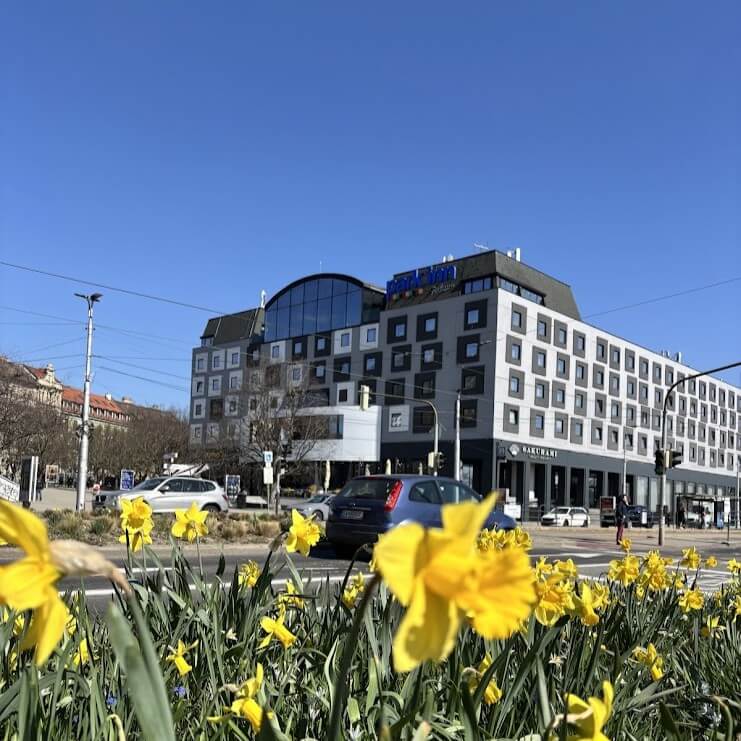 Park Inn by Radisson Danube Hotel Bratislava exterior on a sunny day with yellow daffodils in the foreground