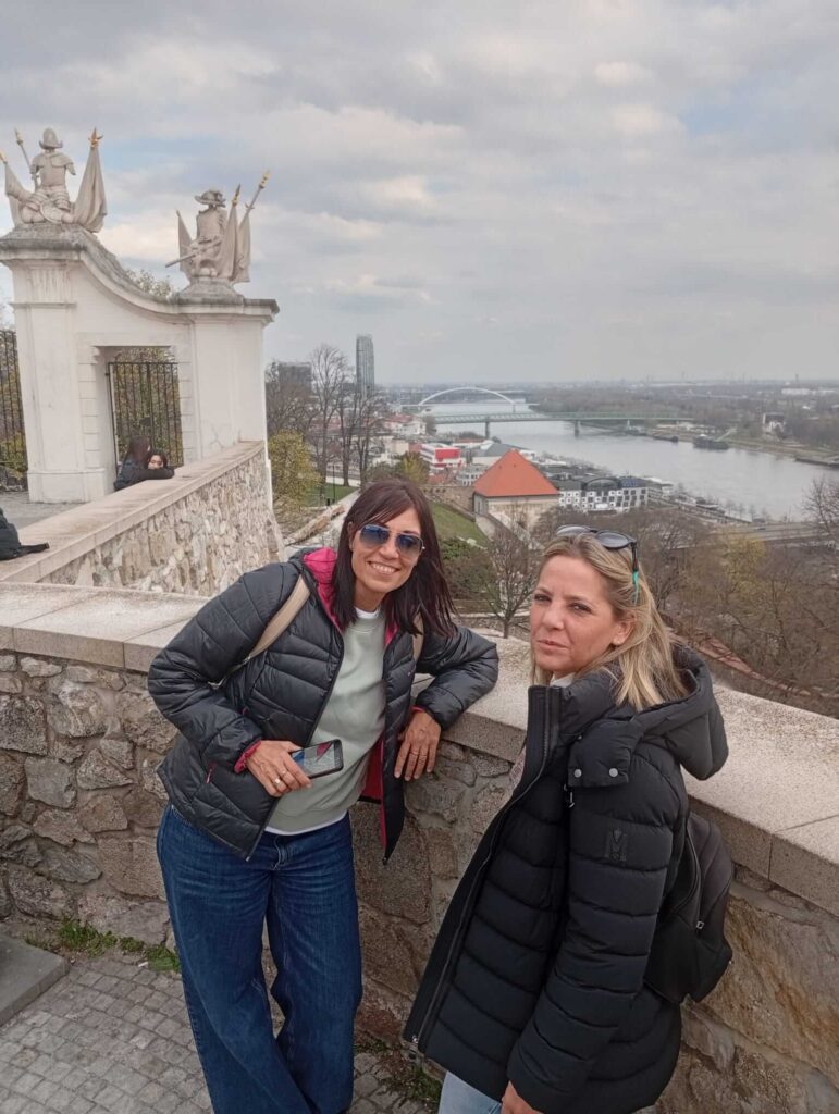 Two visitors enjoying the panoramic view of the Danube River from Bratislava Castle terrace during a walking tour of Bratislava