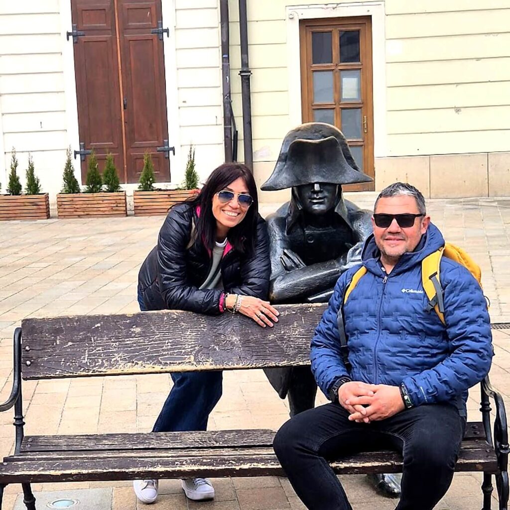 Tourists posing with the Napoleon soldier statue in Bratislava Old Town — a popular stop on a guided walking tour