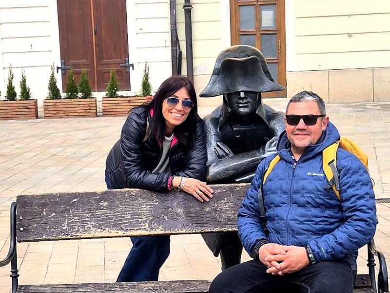Tourists posing with the Napoleon soldier statue in Bratislava Old Town — a popular stop on a guided walking tour