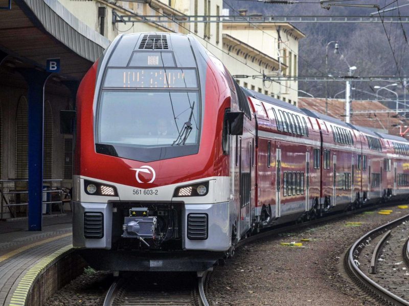 Red ZSSK passenger train on the Bratislava to Budapest railway route through the Slovak mountains
