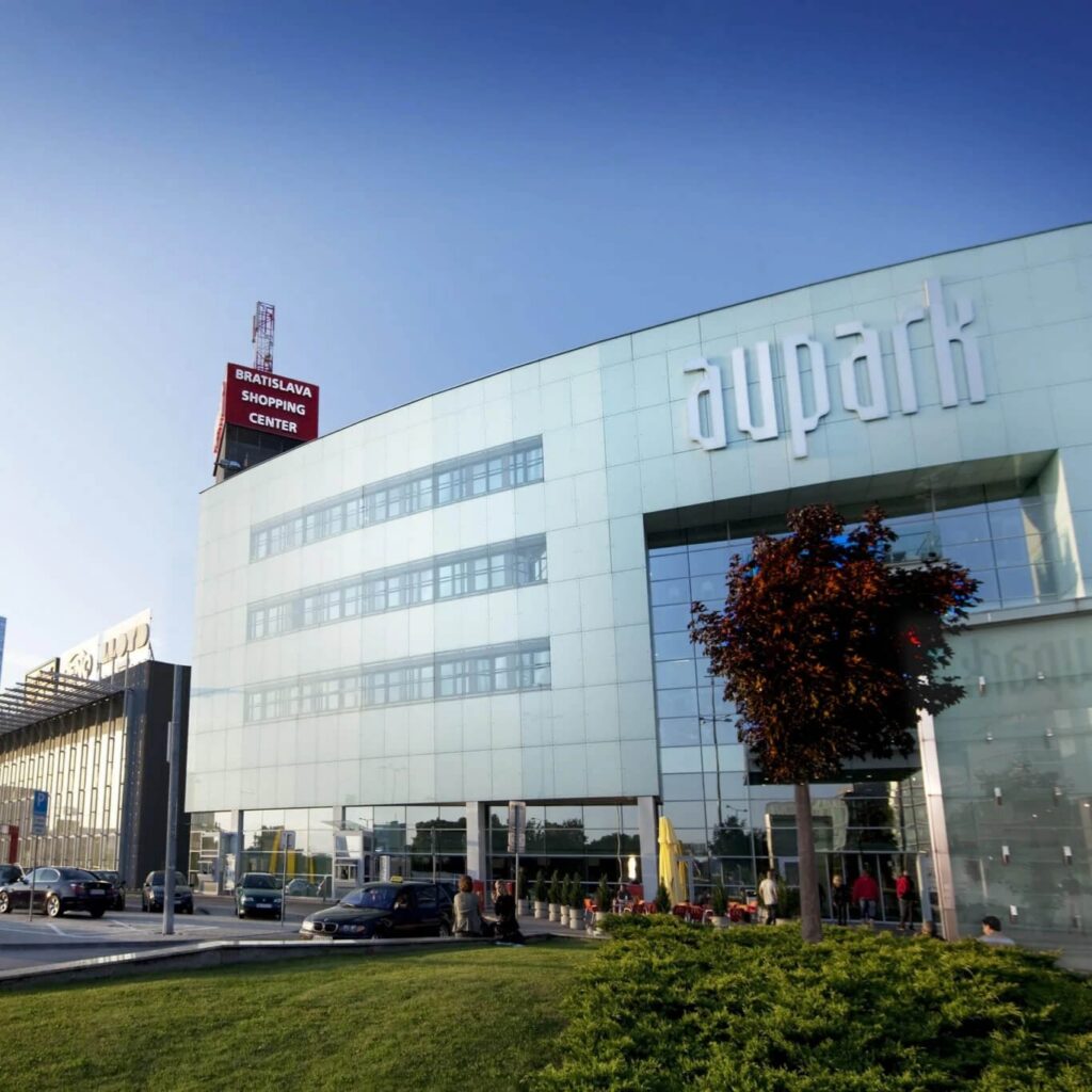 Aupark Shopping Center exterior in Bratislava with glass facade and rooftop sign